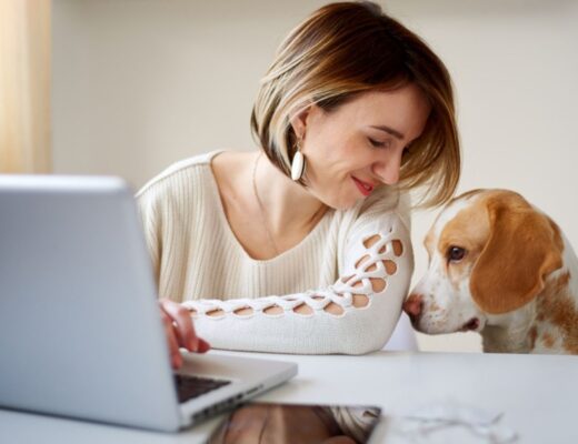 happy woman with her dog at the computer